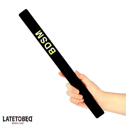 Hand holding Latetobed BDSM Line Spanking Paddle 38 cm made of durable PVC for intense consensual play.