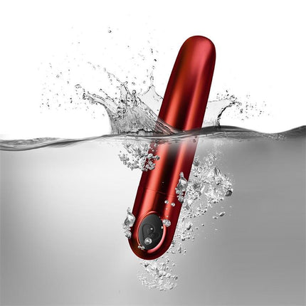 Truly Yours Vibrating Bullet Ruby Caress Metallic Red floating in water, showcasing its sleek design and waterproof feature.
