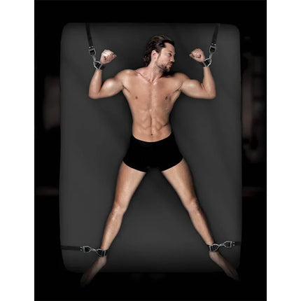 Man demonstrating Under-Mattress Bondage Straps on bed, showcasing secure and adjustable restraint with industrial nylon and sturdy cuffs.