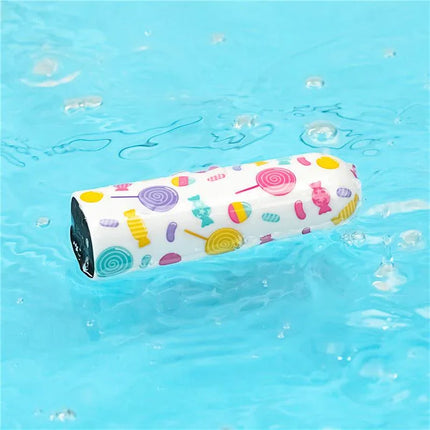 Vibrating Bullet Lollipop floating on water with colorful candy patterns for discrete pleasure and easy portability.