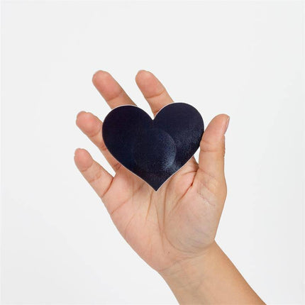 Hand holding Wow Boobs! Nipple Covers Heart Shapped Holographic in opaque finish, showcasing playful and sensual accessory design.